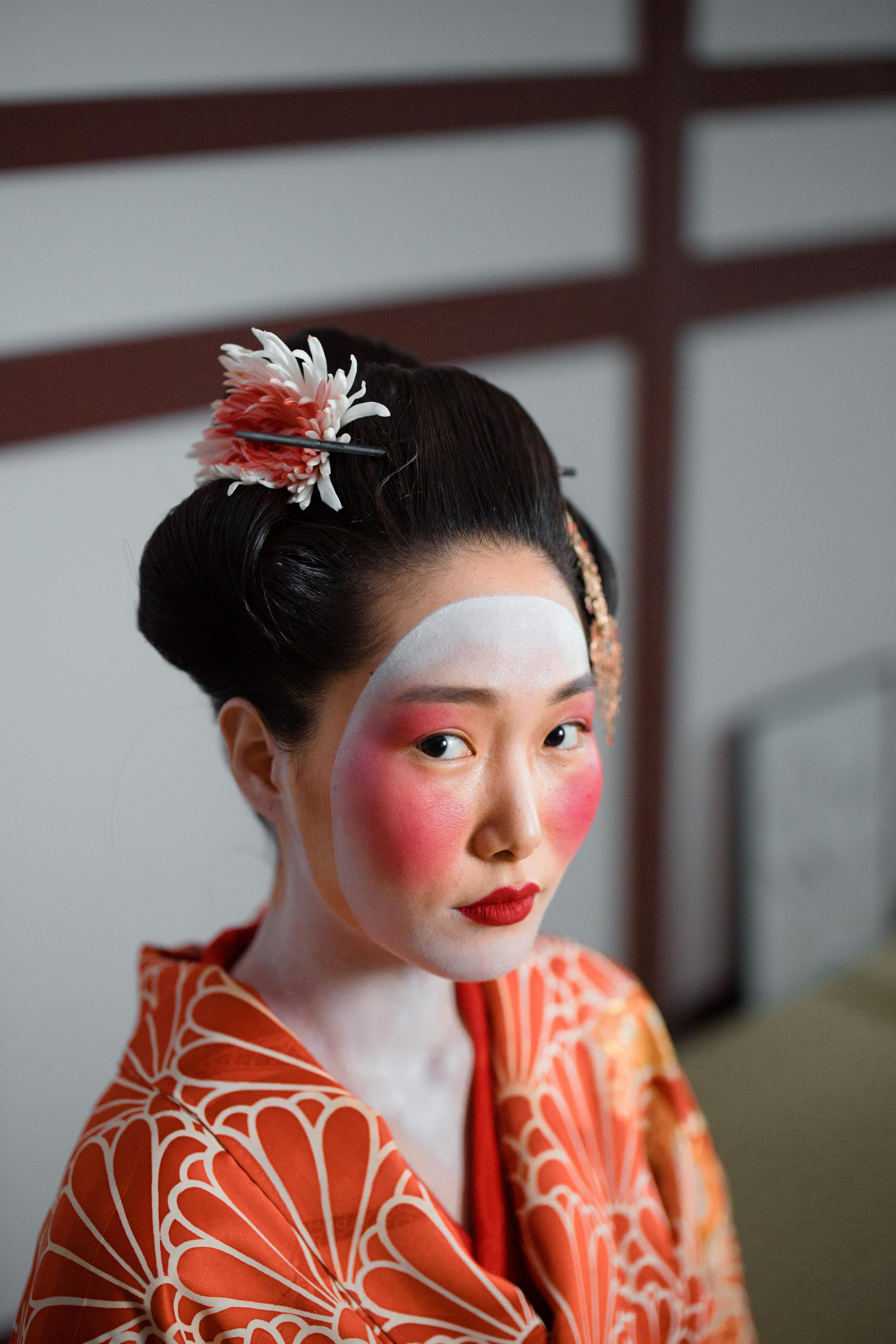 Image of Two Young Beautiful Japanese Geishas accoutered in the ceremonial  costumes