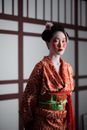 Woman in Red Floral Kimono Standing Near the Wall