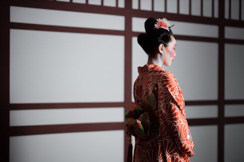 Girl in Red  Floral Kimono Standing Near White Wall