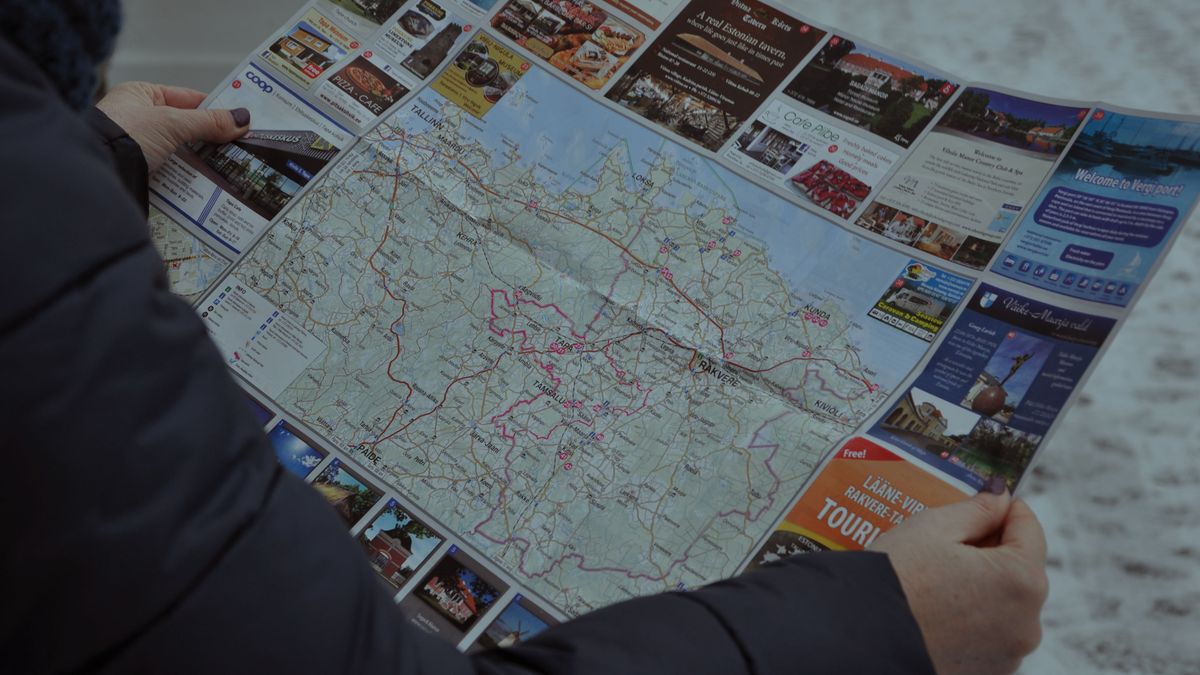 A person examining a detailed map outside during winter, focusing on directions.