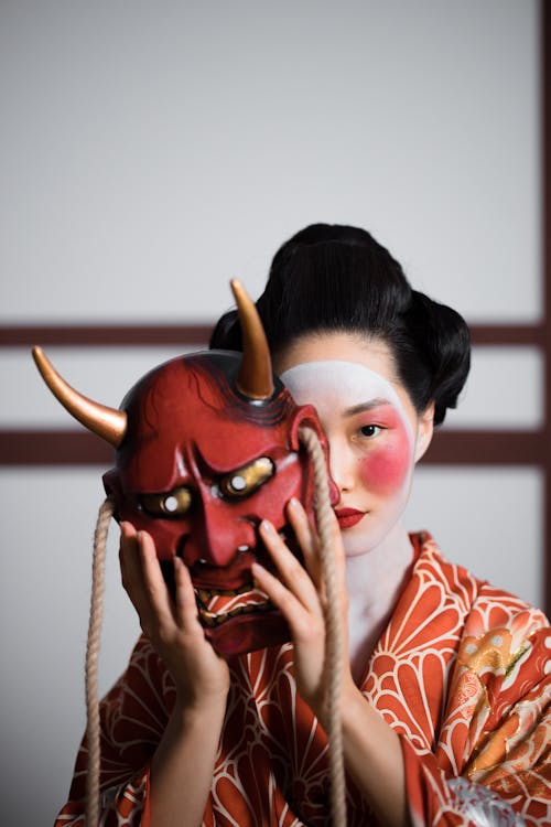 A Geisha Holding a Mask