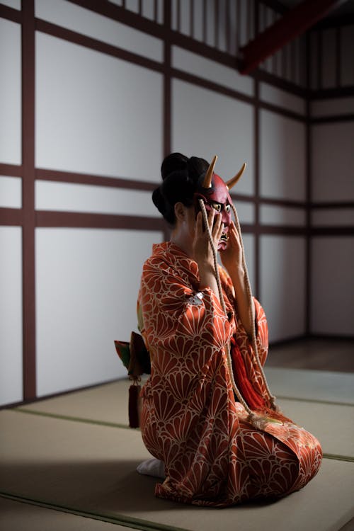 A Woman in a Kimono Holding a Hannya Mask 