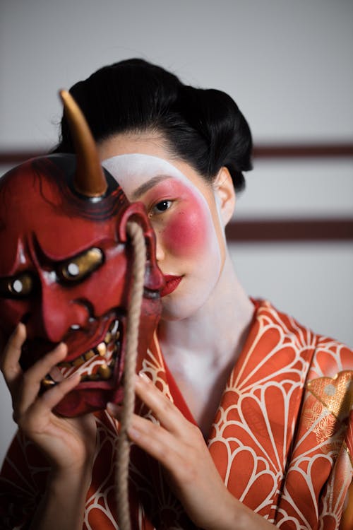 A Geisha Holding a Hannya Mask 