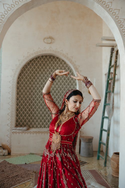 A Woman in Red Saree Dancing a Traditional Dance