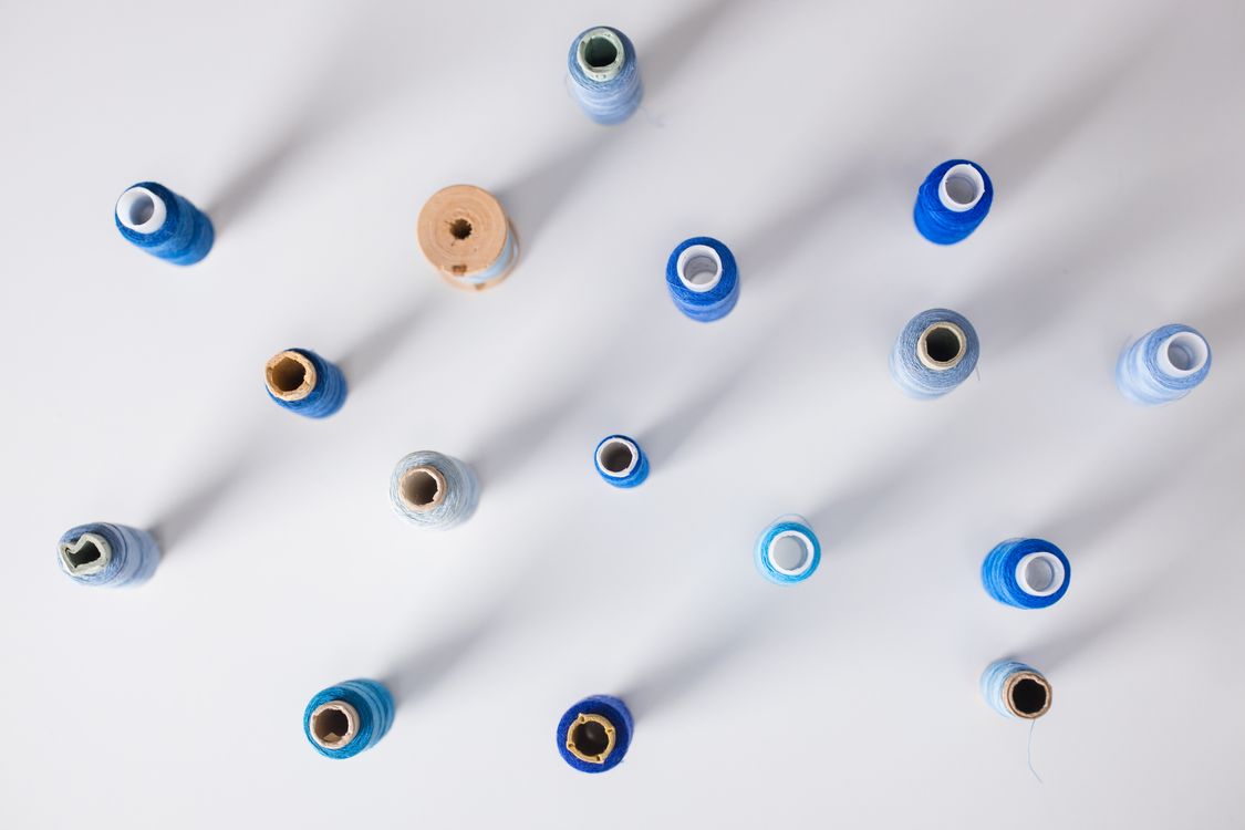 Assorted Blue Sewing Threads on White Surface · Free Stock Photo