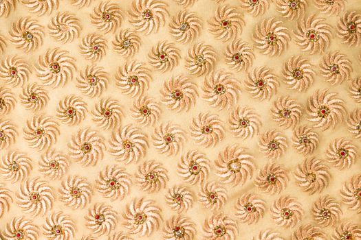 Close-up of a detailed textile design featuring spiral motifs with beads and sequins.