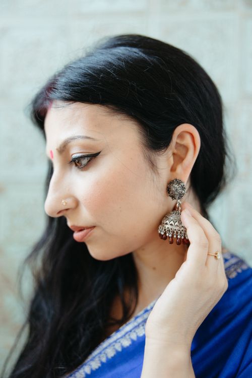 Free Side view of a woman wearing a sari and traditional jewelry, exuding elegance. Stock Photo