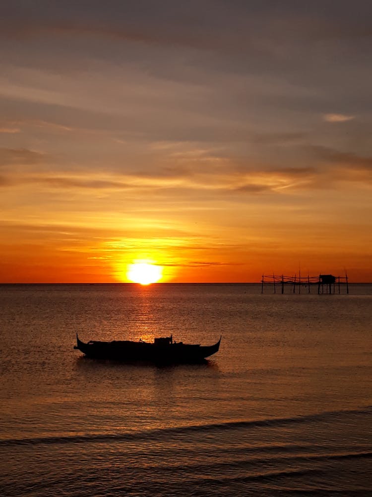 Boat Anchored On Sea During Sunset