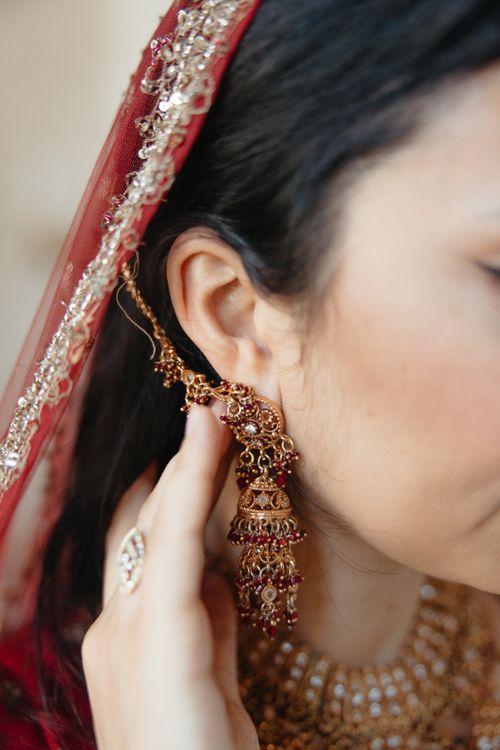 Free Detailed shot of a woman in traditional Indian attire showcasing ornate dangling earrings and headscarf. Stock Photo