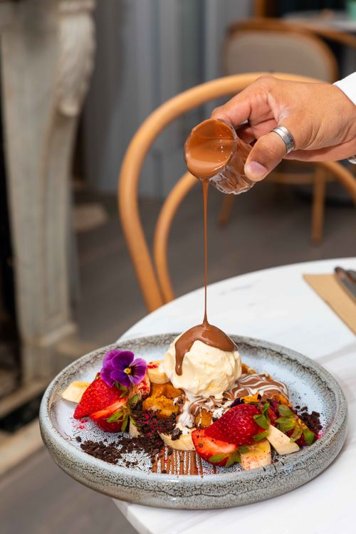 Free A gourmet dessert with chocolate sauce and ice cream dripped over fruits and cake. Stock Photo