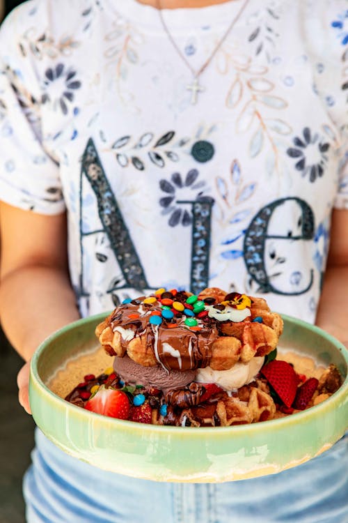 Free Person Holding A Green Ceramic Bowl With Candies On Waffles and Ice Cream  Stock Photo