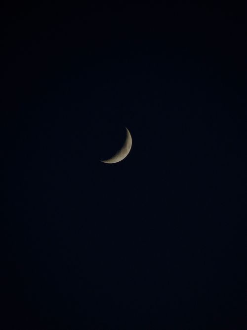 Free Crescent moon with spots glowing on dark sky at night high in universe Stock Photo