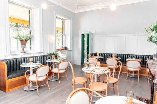 Restaurant Interior with White Walls and Wooden Chairs and Tables