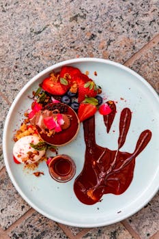 Creative chocolate dessert plate with strawberries and blueberries on textured surface.