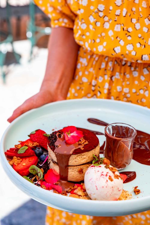 Free Elegant dessert featuring chocolate pancakes, ice cream, and fresh berries on a sunny plate. Stock Photo