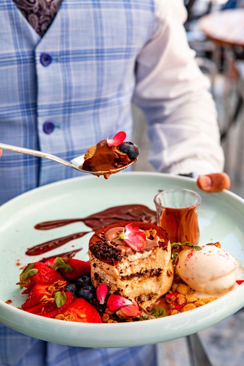Free Gourmet dessert with berries, chocolate sauce, and ice cream on a plate, elegantly served. Stock Photo