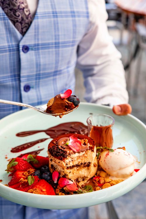 Free Delicious dessert with chocolate, fruits, and ice cream served elegantly on a plate. Stock Photo