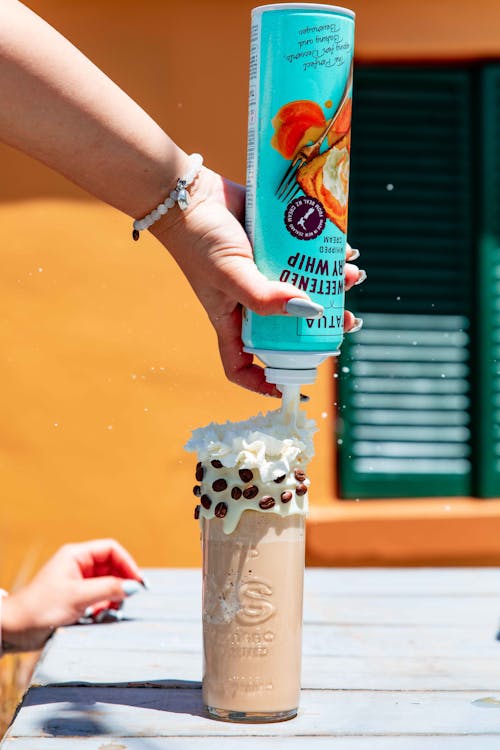 Person Holding Light Blue Can with White Cream