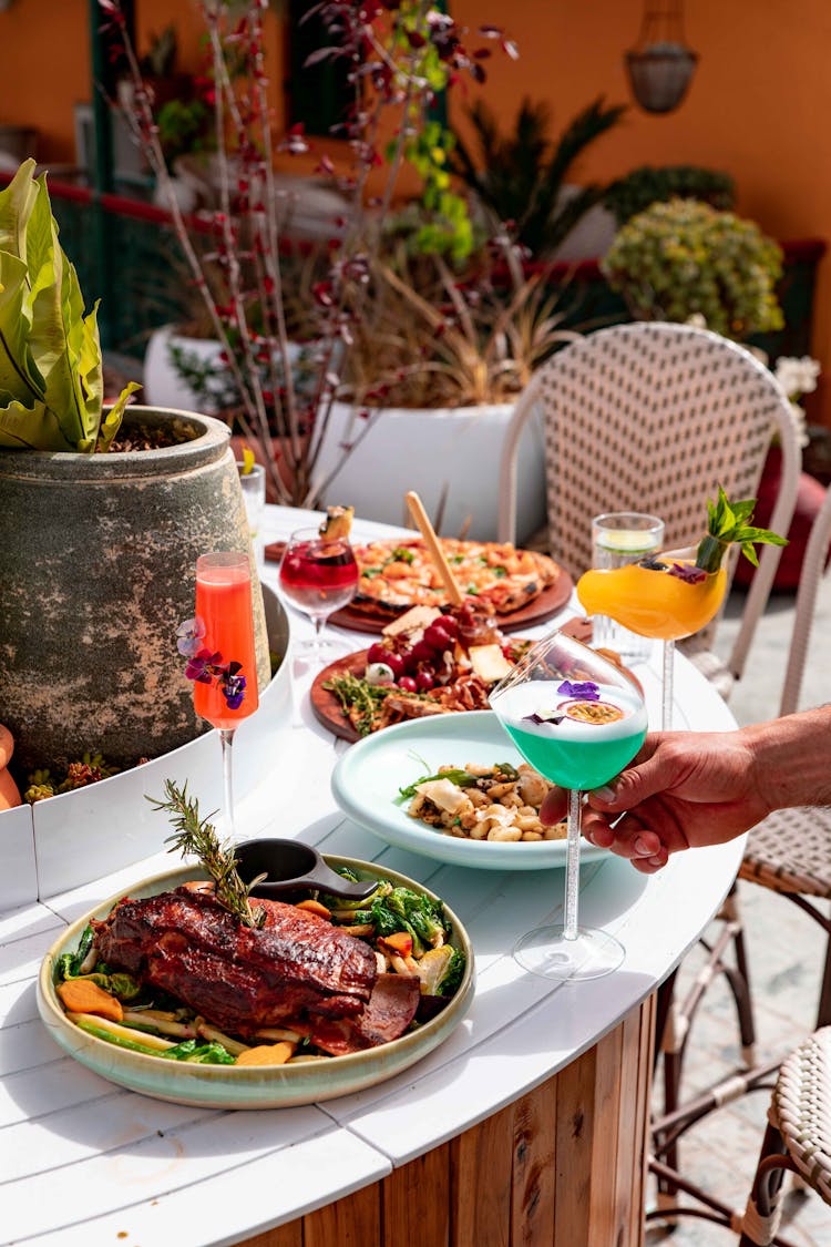 Assorted Cooked Food And Cocktails On Table