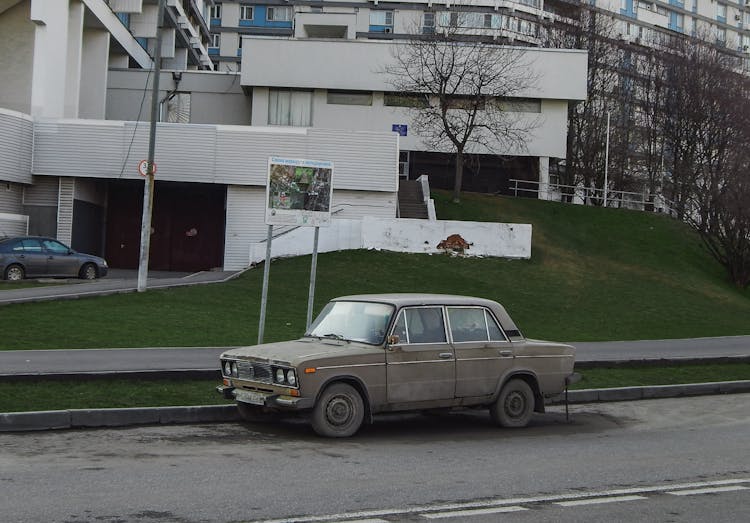 Damaged Vintage Car Parked On The Sidewalk