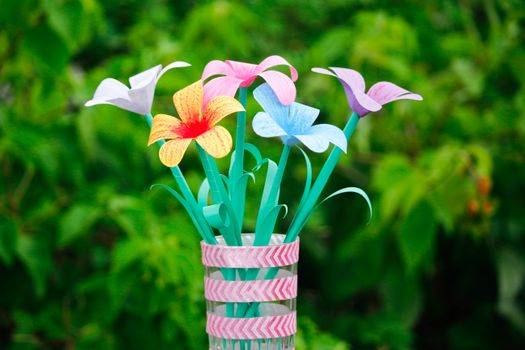 Vibrant paper flowers in a decorative vase, perfect for creative decor.