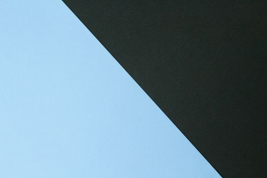 Simple minimalist abstract image featuring intersecting black and blue colored paper.
