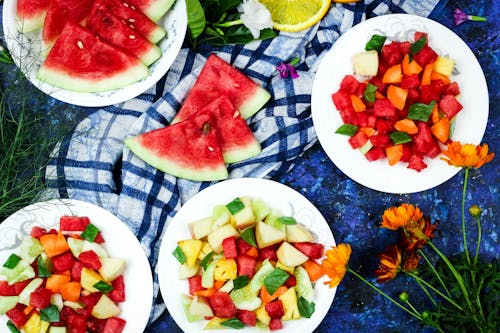 Free Slices of Mixed Fruits on Plates Near Slices of Watermelon Stock Photo