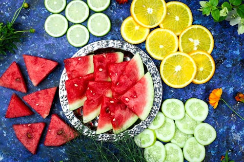 Variety of Sliced Fruits on Blue Surface