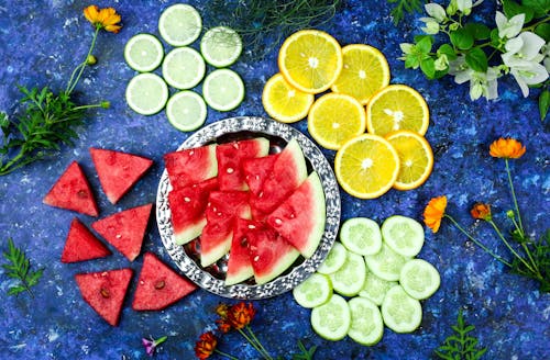 Slices of  Tropical and Citrus Fruits on Blue Surface