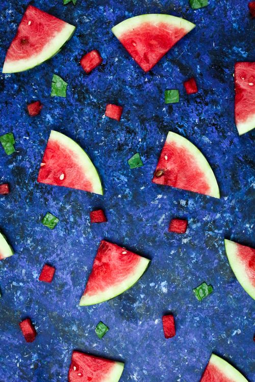 Free Colorful arrangement of watermelon slices and cubes on a textured blue surface, captured from above. Stock Photo