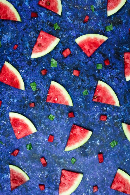 Free Juicy watermelon slices and cubes on a vibrant blue surface, arranged in an artistic pattern. Stock Photo