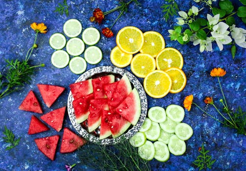 Free Slices of Tropical and Citrus Fruits on Blue Surface Stock Photo