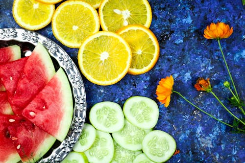 Free Slices of Citrus and Tropical Fruits on Blue Surface Stock Photo