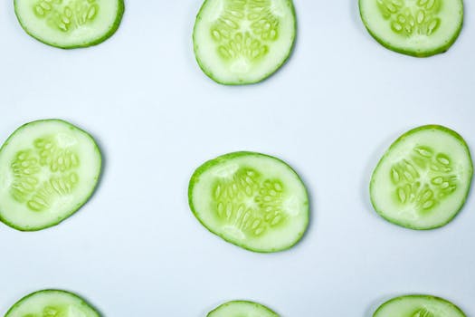 Close-up of fresh cucumber slices in a flatlay pattern on a white background.