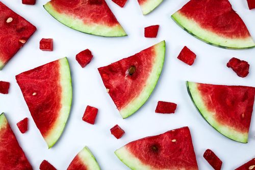 Free Colorful slices of watermelon arranged artistically on a white surface, showcasing their freshness. Stock Photo