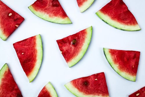 Free Fresh watermelon slices arranged on a white background, highlighting their juicy texture. Stock Photo