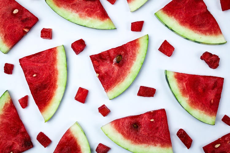 Sliced And Watermelon Bits On A White Surface