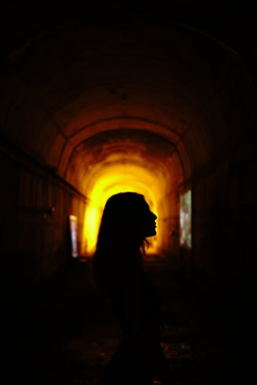 Free Silhouette of Person Standing Inside a Tunnel Stock Photo