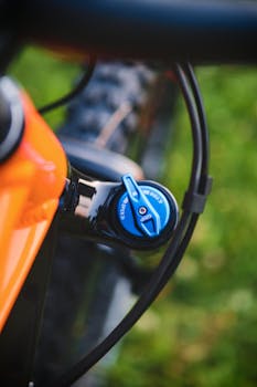 Detailed close-up photo of a blue suspension on an orange mountain bike, highlighting precision technology.