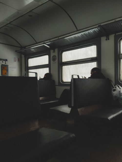 Free Quiet train ride with passengers sitting during daylight hours. Stock Photo