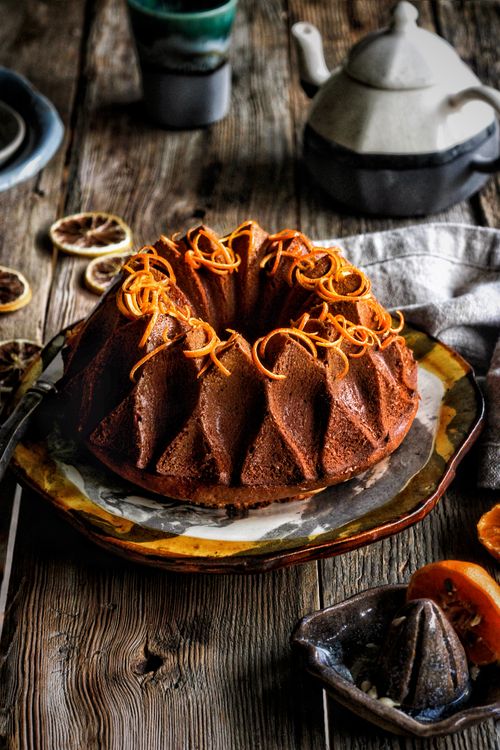Free Delicious chocolate bundt cake with orange zest on rustic table setting. Stock Photo