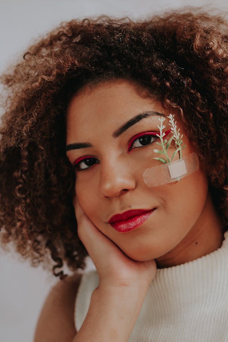 A Woman With A Band Aid On The Face With Plant Sprouts