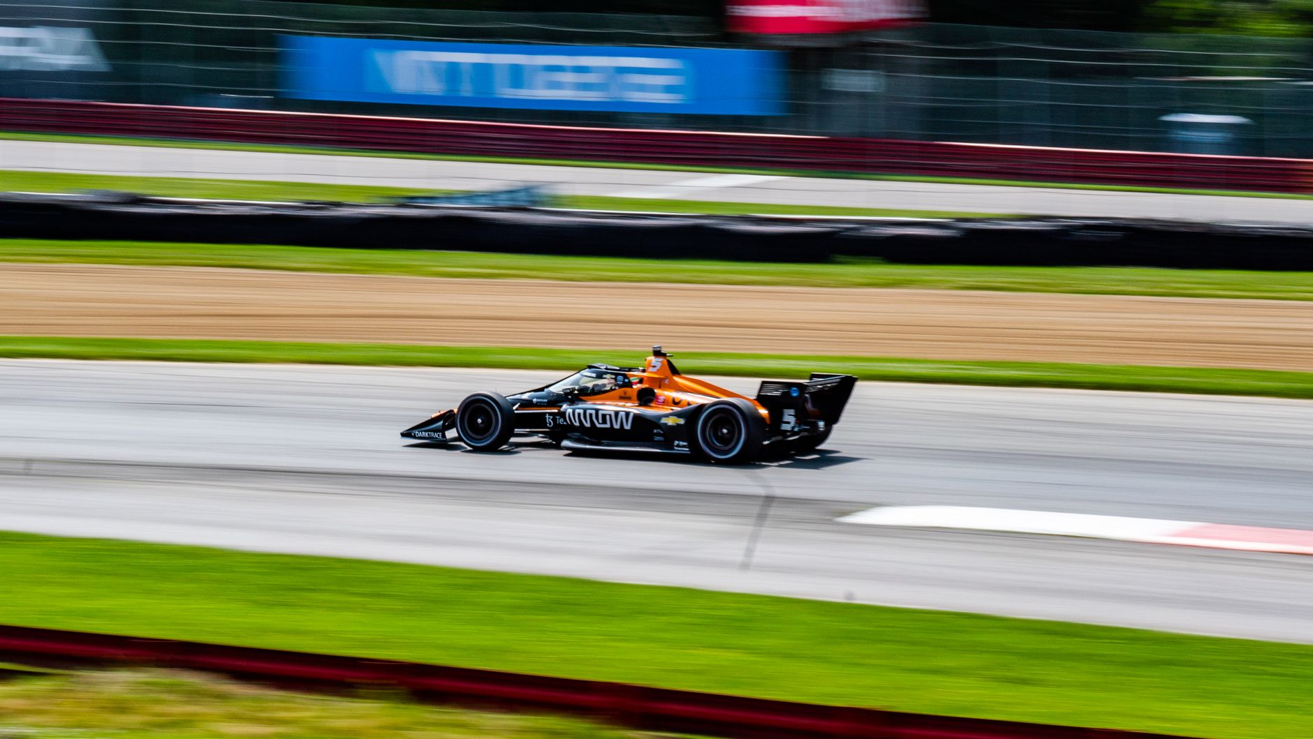 IndyCar speeding on track at Mid-Ohio Sports Car Course. Experience the thrill of motor racing.