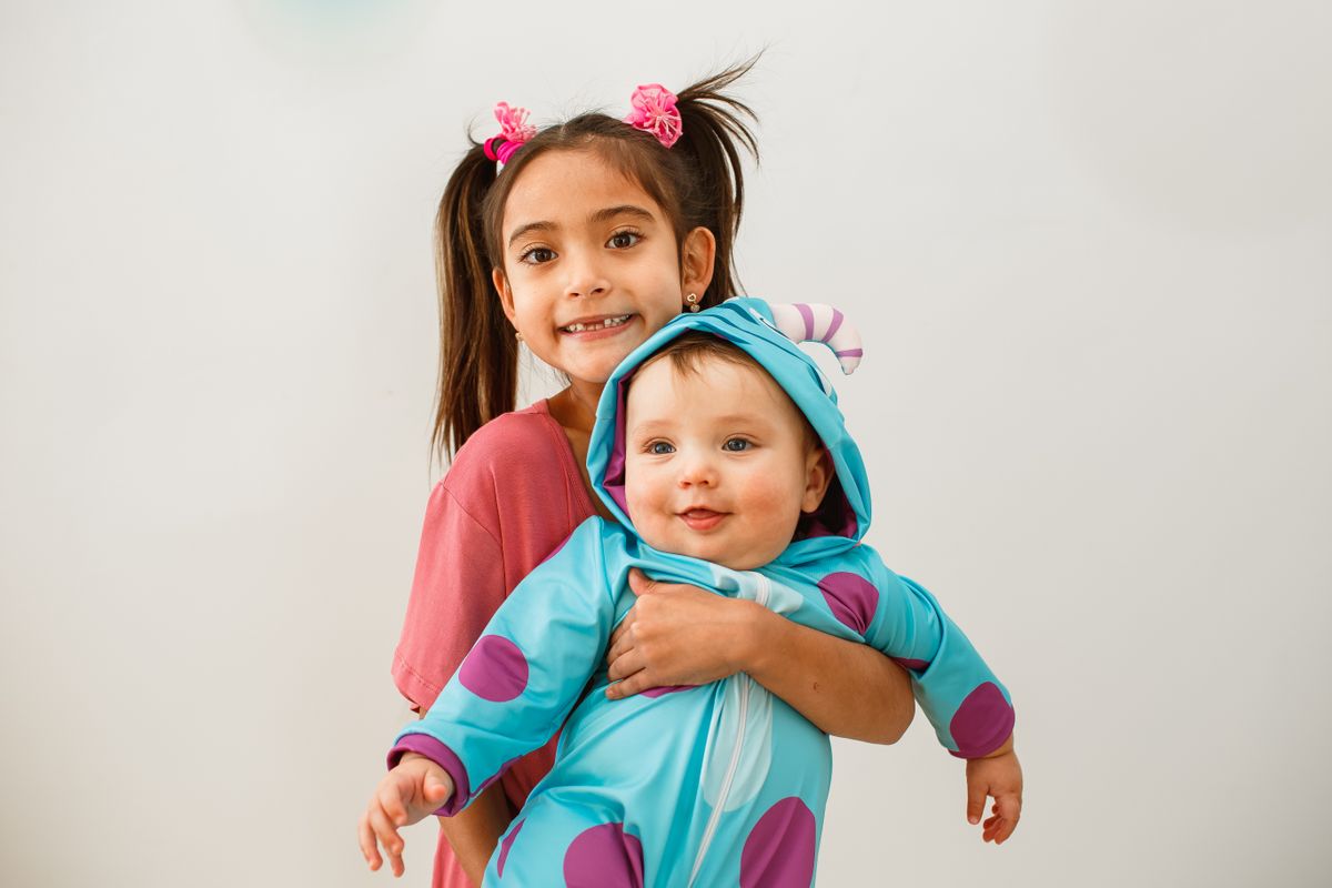 Older sister holding her baby sibling for a sibling photo