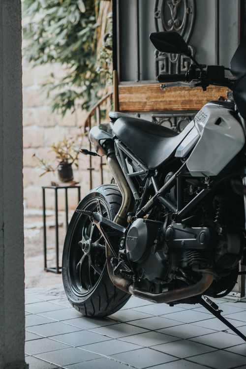 Free Close-up of a parked motorcycle indoors showcasing its detailed engine and sleek design. Stock Photo