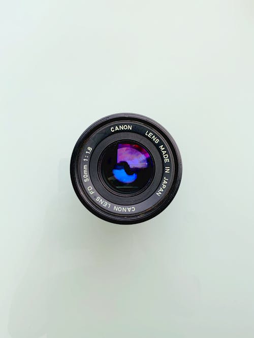 Close-Up Shot of Camera Lens on a White Surface