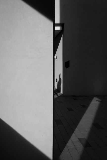 Minimalist black and white photo highlighting geometric architecture and shadows.