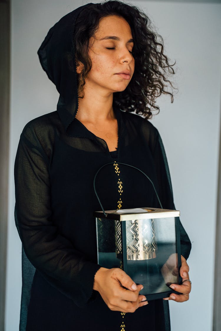 A Woman In Black Top Holding A Lantern