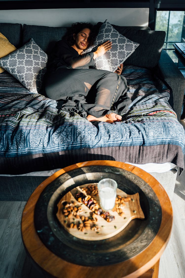 Woman Napping On A Cozy Couch In Shaded Bedroom 