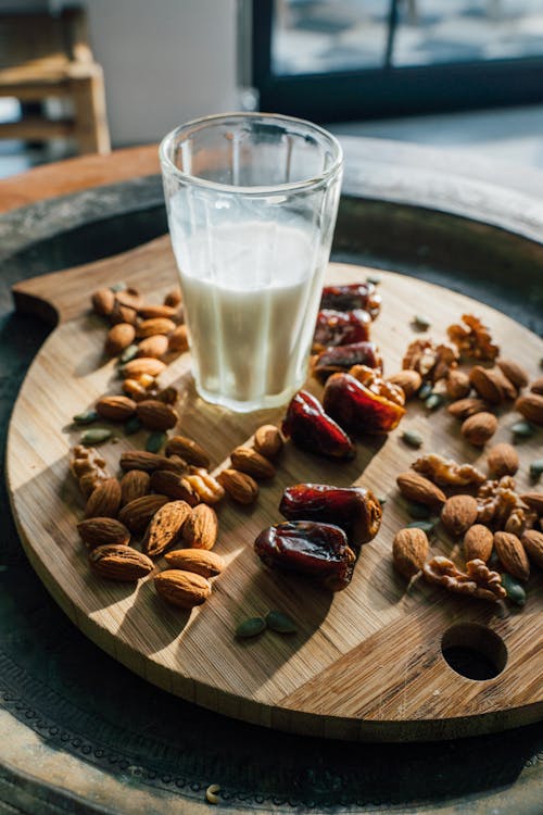 Almonds and Glass of Milk on Wooden Board